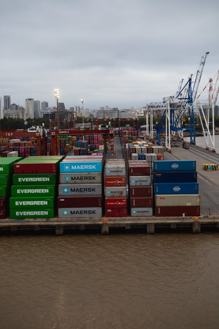 The Art of Drawing Readers In: Your attractive post title goes here A bustling container port showcasing stacked shipping containers and cranes during a cloudy day.